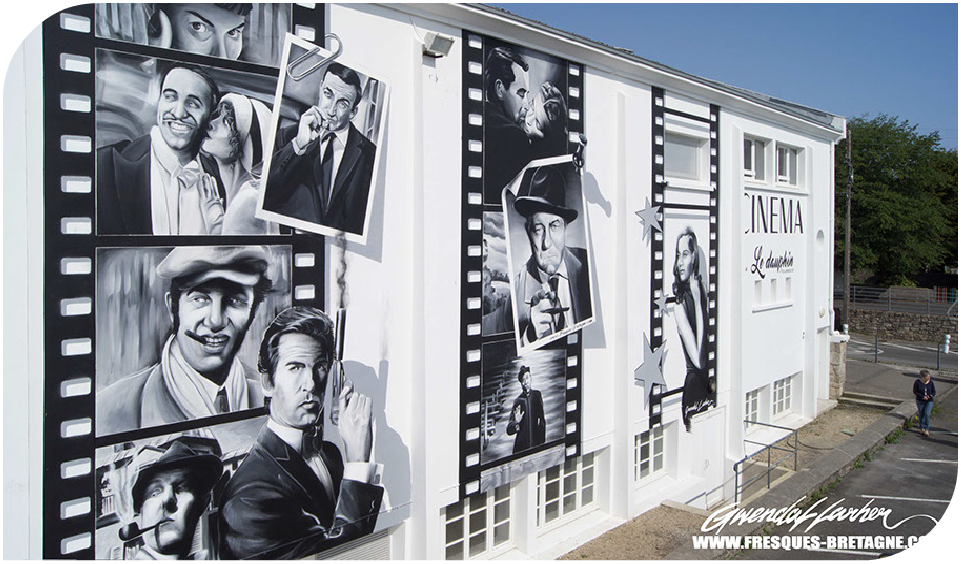 Vue d'ensemble d'une fresque murale monumentale peinte sur la façade d'un cinéma en Bretagne. Le décor en trompe-l'œil 