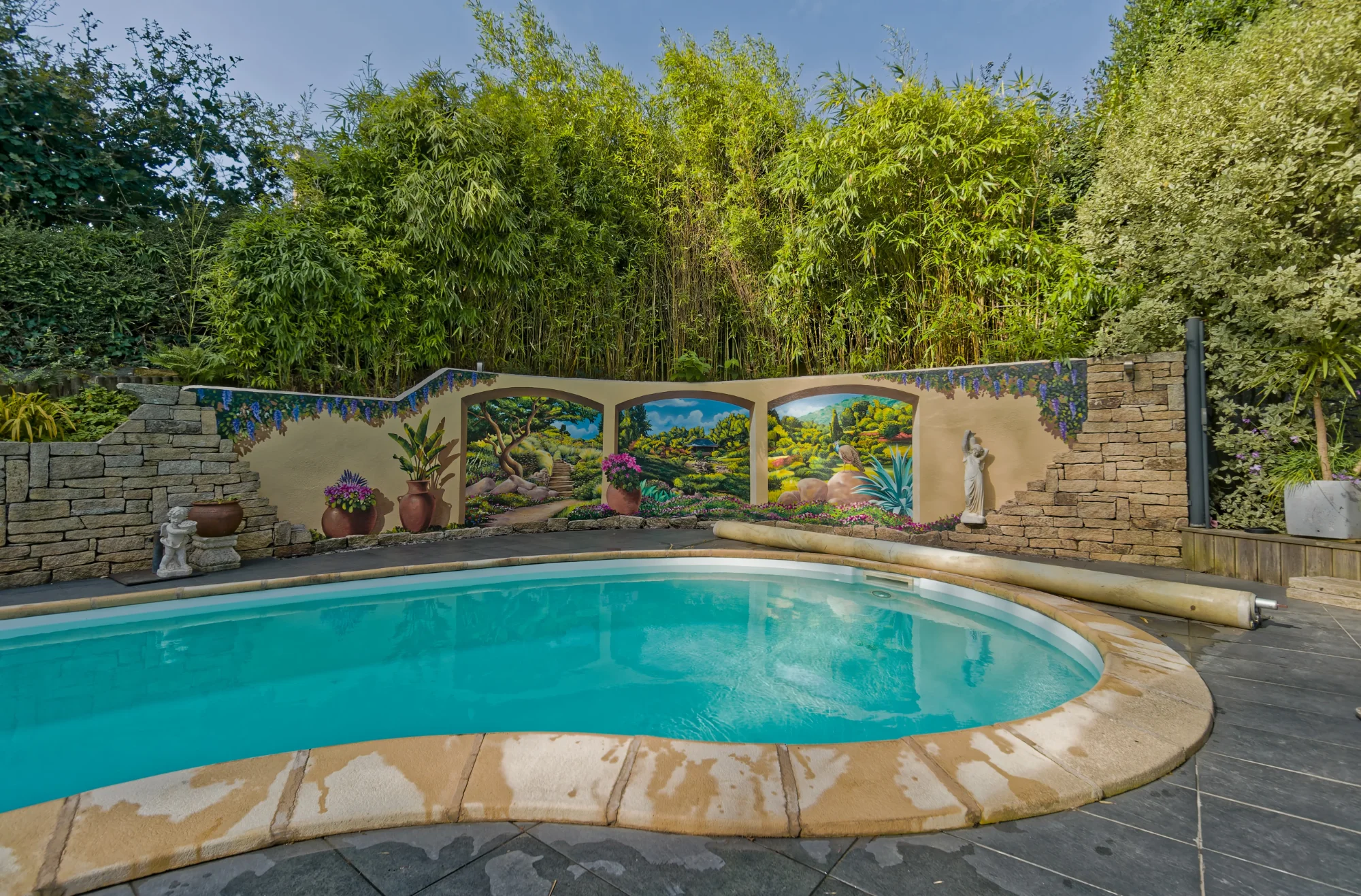Piscine à Perros-Guirec après réalisation : jardin japonais immersif en trompe-l'œil sur le mur d'enceinte, peinture résistante à l'humidité